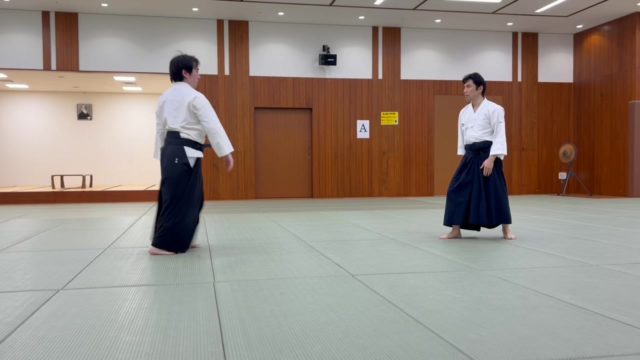 中段突き呼吸投げ（正面当て）の稽古です。  相手の中段突きを半身の入れ替えと転換でかわし、掌底による当身で顎を浮かせて中心軸を崩します。崩れた相手に対し、自身の前進力を途切れさせることなくつなげることで、自然な投げへと導きます。  体捌き、当身、崩し、そして前進力。シンプルな動きの中に合気道の理合いが詰まった技の一つです。  #習い事 #aikidoka #港区 #合気道 #武道 #稽古