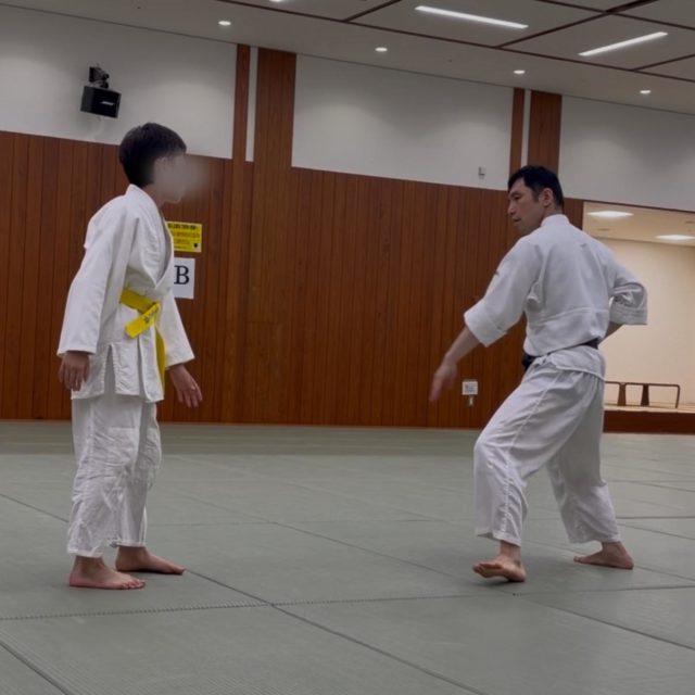 【少年部稽古】  今回は小手返しの稽古を行いました。  相手の中段突きを体を開いてかわすと同時に、面に向けて素早く当身を出します。相手が怯んで生まれた一瞬のスキを捉え、小手返しで崩して投げへとつなげます。  体を開きすぎると当身が届かず、技の流れが途切れてしまうため、最小限の動きで相手の攻撃をさばくことが大切です。  また、当身は相手に実際に当てることが目的ではありません。相手の目の前に素早く出すことで回避行動を引き出し、崩しと技につながるスキを作ります。  少年部でも、一つひとつの動きの意味を理解しながら、安全に、そして楽しく稽古を積み重ねています。  #合気道  #少年部 #港区 #港区スポーツセンター #田町 #三田 #習い事 #武道 #護身術 #小手返し #当身 #姿勢 #体験受付中